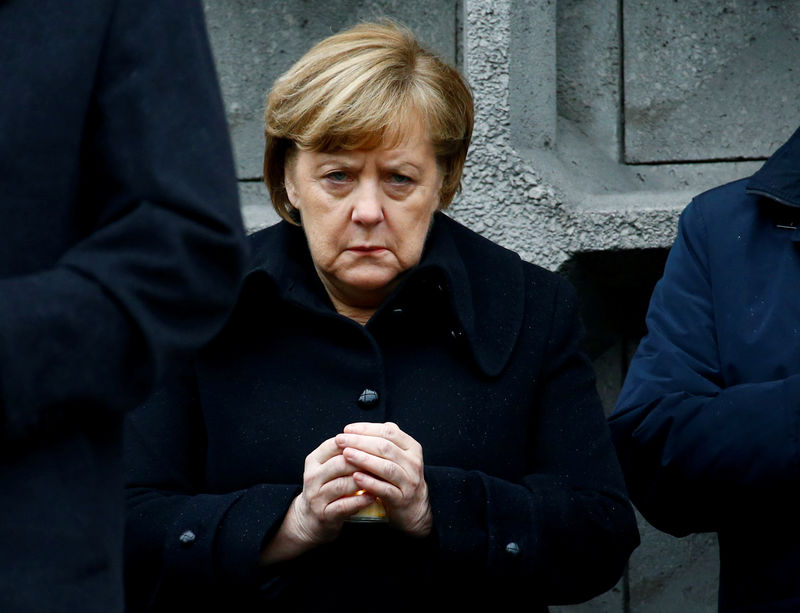 © Reuters. Chanceler alemã, Angela Merkel, segura vela ao participar de memorial no local de um ataque em um mercado natalino em Berlim