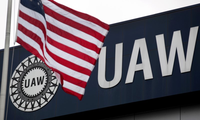 © Reuters. FILE PHOTO: An American flag flies in front of the United Auto Workers union logo  in Detroit