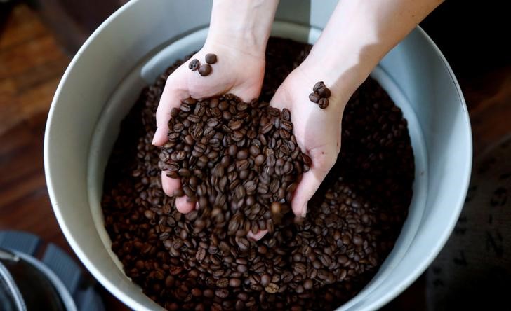 © Reuters. Funcionária posa com grãos de café torrados em torrefadora em Berlim, Alemanha