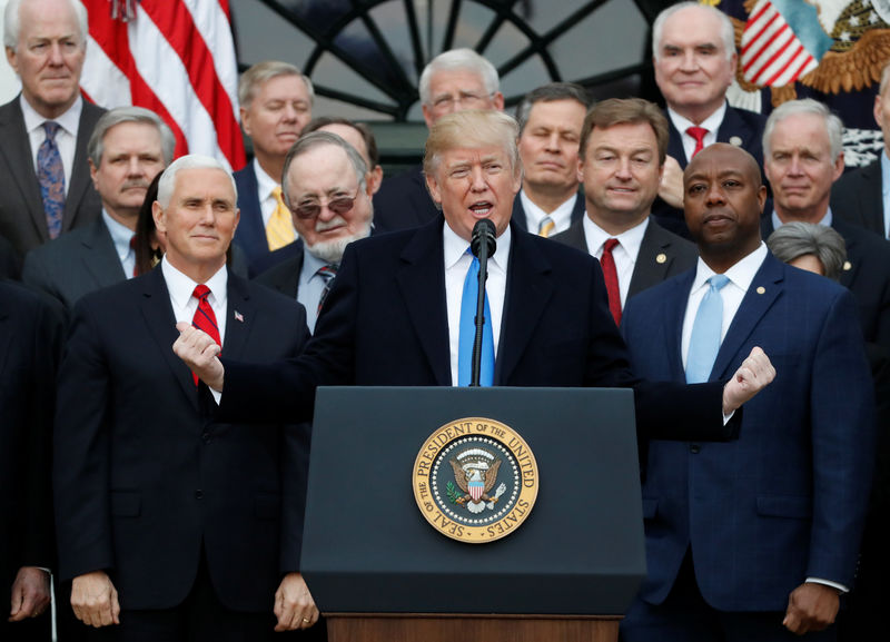 © Reuters. U.S. President Donald Trump speaks flanked by Vice President Mike Pence and Senator Tim Scott after the U.S. Congress passed sweeping tax overhaul legislation, on the South Lawn of the White House in Washington