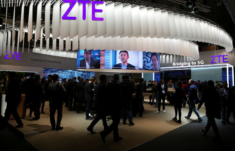 © Reuters. FILE PHOTO: People stand at ZTE's booth during Mobile World Congress in Barcelona