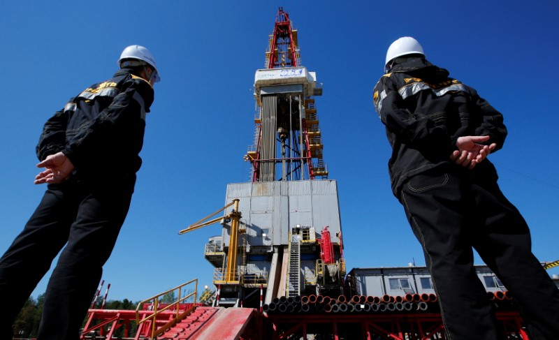 © Reuters. File photo of workers looking at drilling rig at well pad of Rosneft-owned Prirazlomnoye oil field outside Nefteyugansk