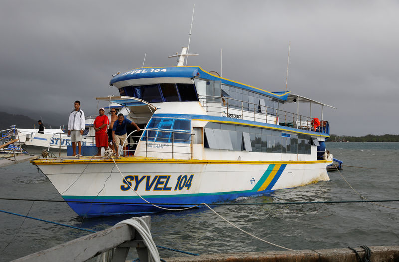 © Reuters. Stranded passengers stand on a passenger boat after all ferry service were cancelled in Real, Quezon