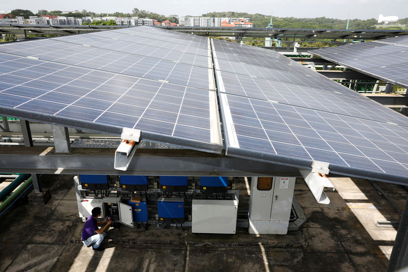 © Reuters. An Electrify SG engineer shows how a powerport is installed to record data of photovoltaic solar panels on a rooftop in Singapore