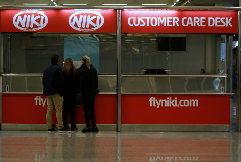 © Reuters. People stand in front of an empty Niki customer care desk at Palma de Mallorca airport