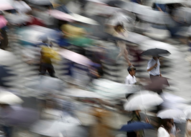 © Reuters. People holding their umbrellas cross a street in Tokyo