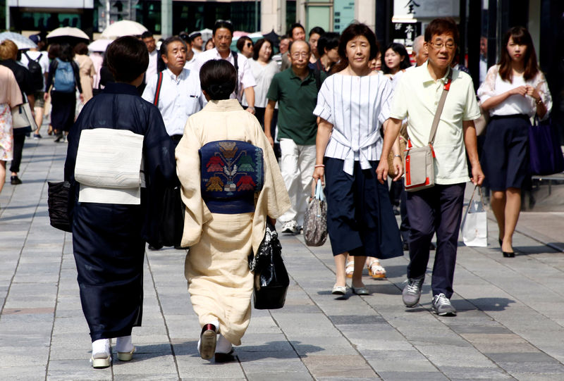 © Reuters. FILE PHOTO: Women in traditional costume 'Kimono' make their way at a shopping district in Tokyo