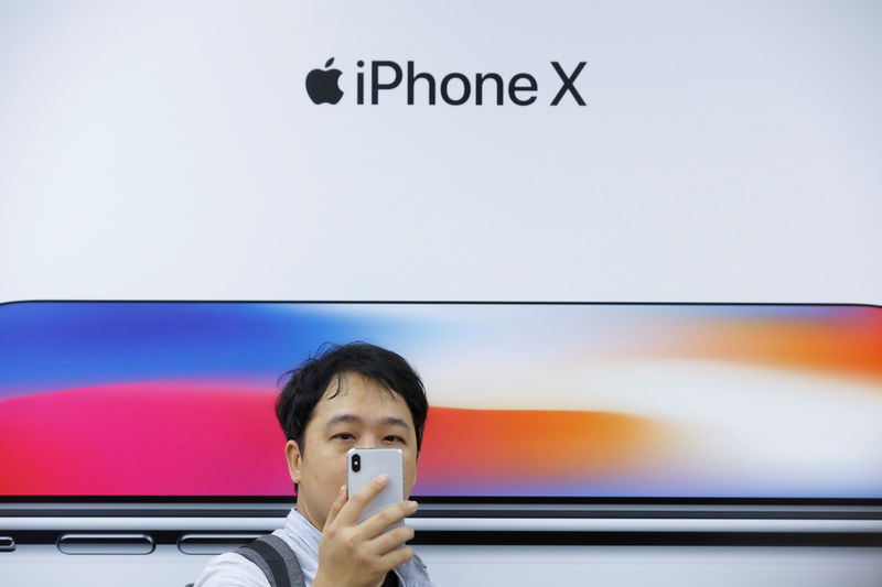 © Reuters. FILE PHOTO: An attendee uses a new iPhone X during a presentation for the media in Beijing