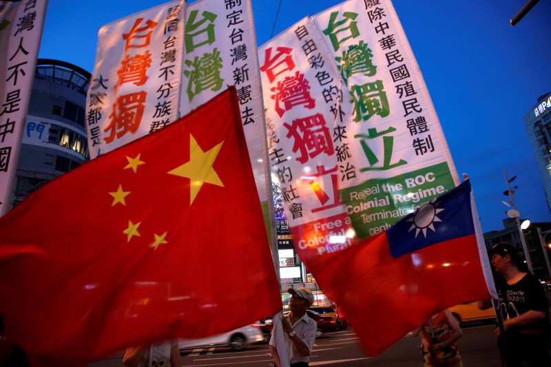 © Reuters. Members of a Taiwanese independence group march with flags around a group of pro-China supporters holding a rally calling for peaceful reunification in Taipei, Taiwan