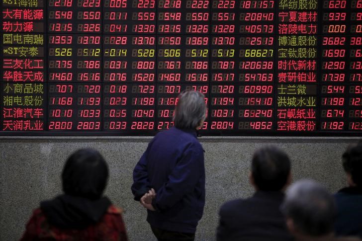 © Reuters. Investidores observam dados de ações em quadro eletrônico de casa de corretagem em Xangai, na China