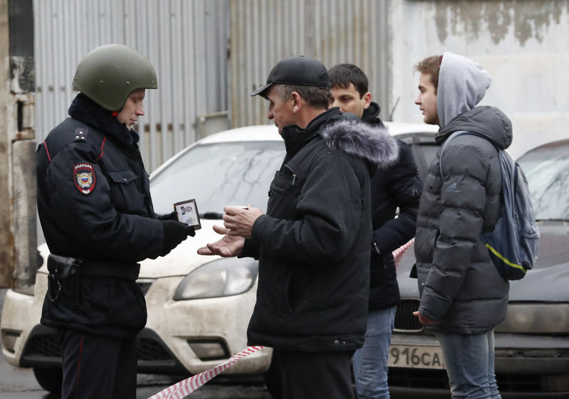 © Reuters. Homem mostra documento a policiais perto de fábrica de massas em Moscou