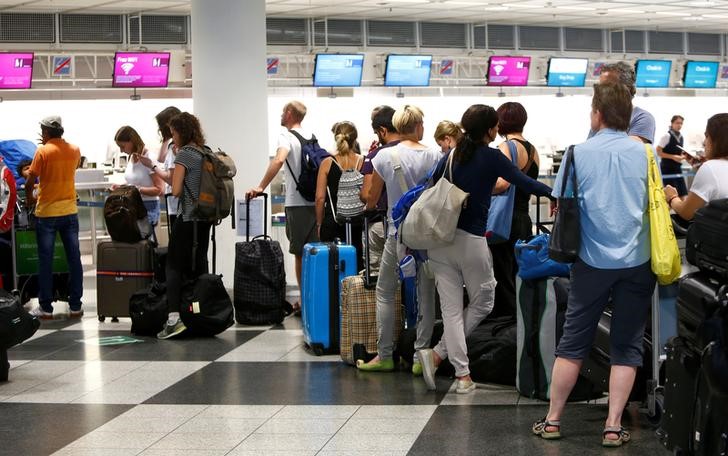 © Reuters. FILE PHOTO: People queue to check in at Munich airport