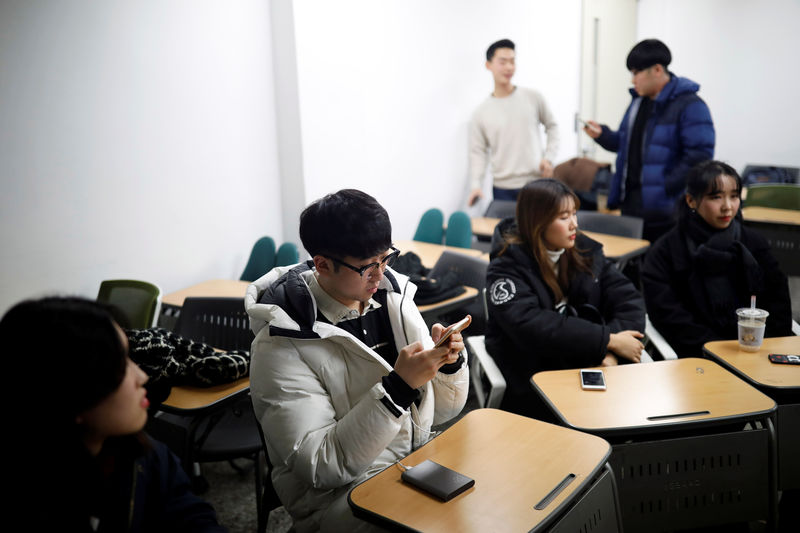 © Reuters. Eoh Kyung-hoon, leader of a club studying cryptocurrencies, checks his mobile phone after a meeting at a university in Seoul