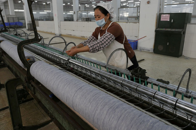 © Reuters. FILE PHOTO: A worker disentangles wool yarn at a spinning machine at a factory owned by Hong Kong's Novetex Textiles Limited in Zhuhai City, Guangdong Province, China