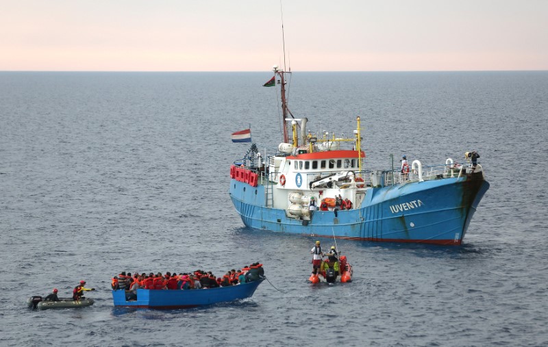 © Reuters. Inmigrantes en un bote de madera son rescatados por la tripulación del barco "Juventa" de la ONG alemana Jugend Rettet en el Mar Mediterráneo costa afuera de Libia
