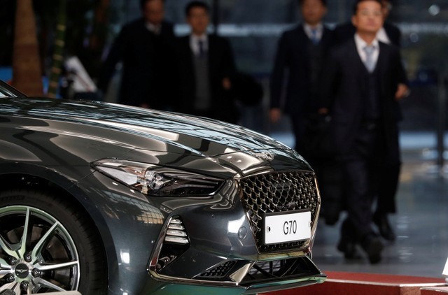 © Reuters. Employees of Hyundai Motor walk past a Hyundai Genesis G70 after the company's New Year ceremony in Seoul