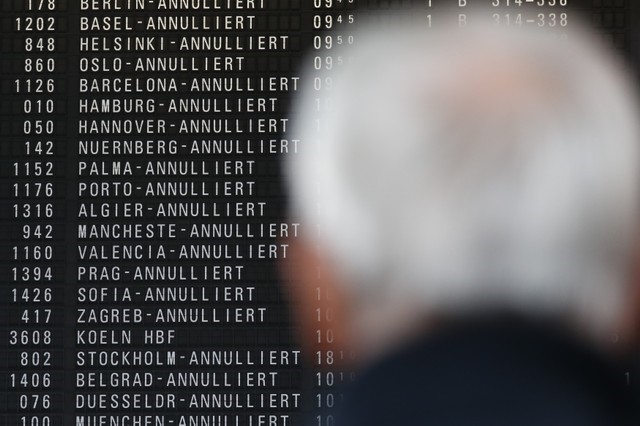 © Reuters. FILE PHOTO - A man looks at a flight information board with cancelled flights in Frankfurt airport