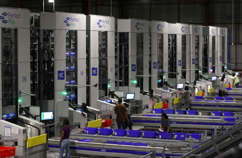 © Reuters. FILE PHOTO: Workers on automated systems at the Hudson's Bay Company distribution centre in Toronto.