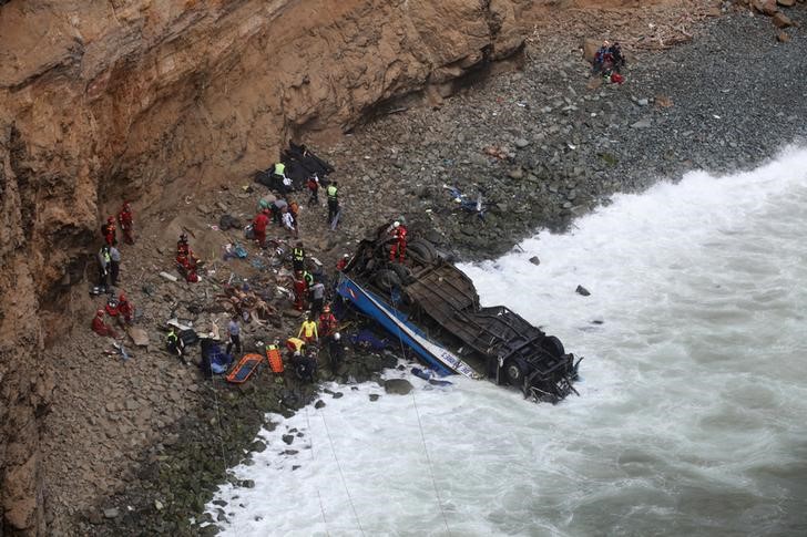 © Reuters. Equipes de resgate e policiais trabalham em local de acidente de ônibus ao norte de Lima, no Peru