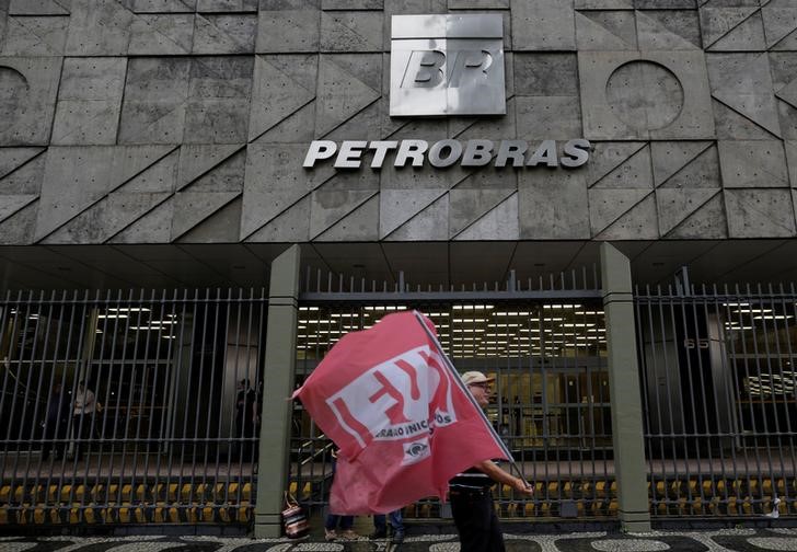 © Reuters. A man walks in front the headquarters of Brazil's state-run Petrobras oil company, during a protest against the privatisation of state owned companies in Rio de Janeiro