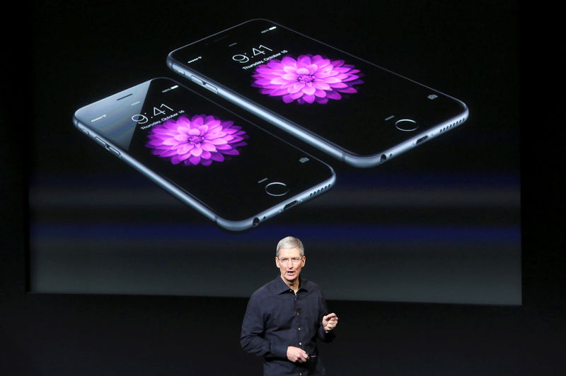 © Reuters. FILE PHOTO: Apple CEO Tim Cook stands in front of a screen displaying the IPhone 6 during a presentation at Apple headquarters in Cupertino