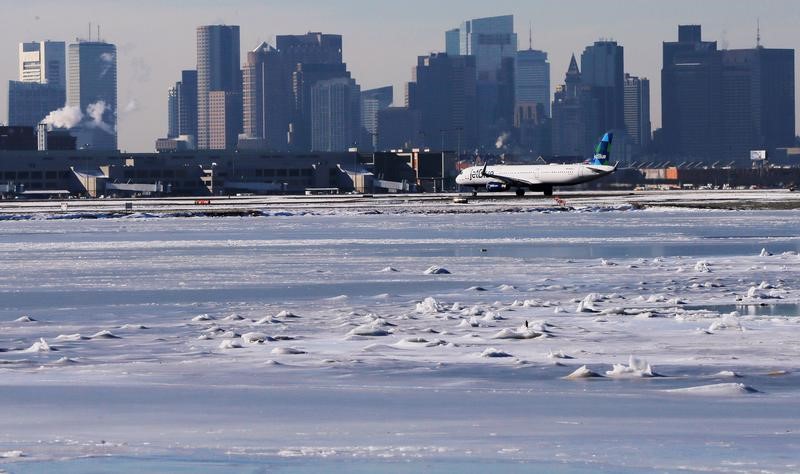 © Reuters. A Jet Blue flight waits to take off from Logan Airport next to the frozen waters of the harbour between Winthrop and Boston