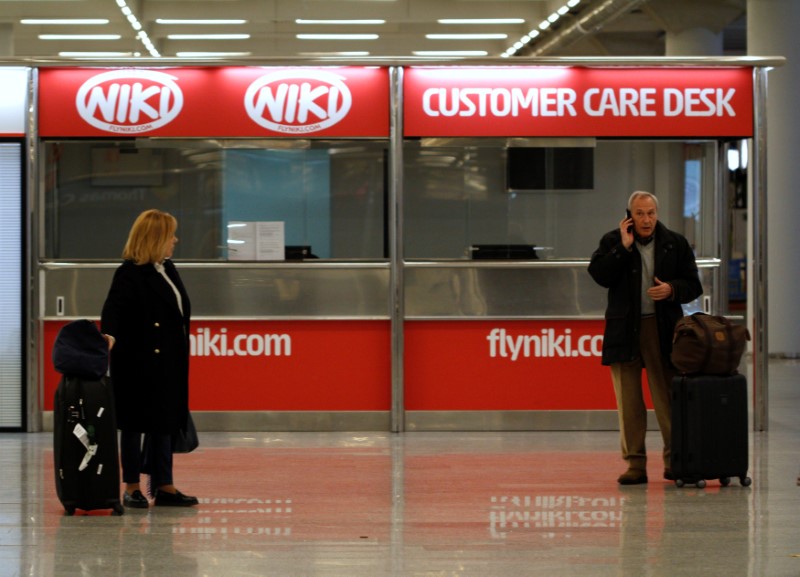 © Reuters. A couple stand near an empty Niki customer care desk at Palma de Mallorca airport