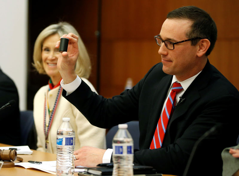 © Reuters. Chairman of the Virginia Department of Elections hold up a film canister containing the name of the winner of a random drawing to determine the winner of the 94th House of Delegates District Seat in Richmond, Virginia