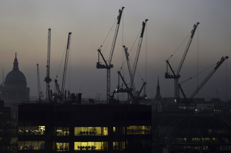 © Reuters. Offices are seen at dusk as St. Paul's Cathedral and construction cranes are seen on the skyline in the City of London, Britain