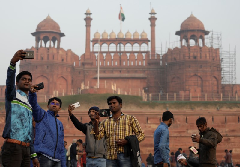 © Reuters. Domestic tourists take selfies in front of the historic Red Fort in the old quarters of Delhi