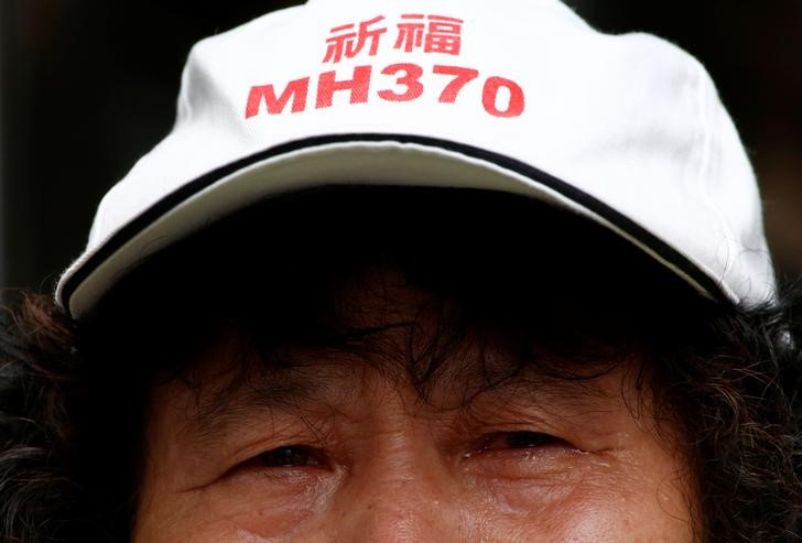 © Reuters. Familiar de passageiro que estava a bordo do voo MH370 da Malaysia Airlines que desapareceu em 2014 durante protesto, em Pequim