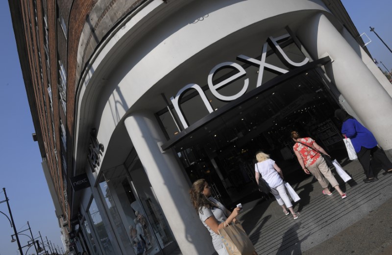 © Reuters. FILE PHOTO: Shoppers pass a branch of Next retail in London, Britain