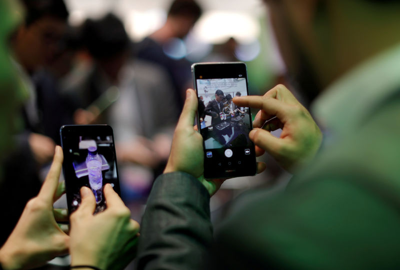 © Reuters. FILE PHOTO: Visitors try Huawei's devices during Mobile World Congress in Barcelona