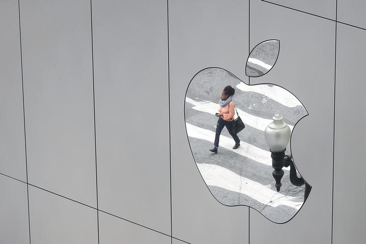© Reuters. A woman is reflected in a Apple store logo in San Francisco