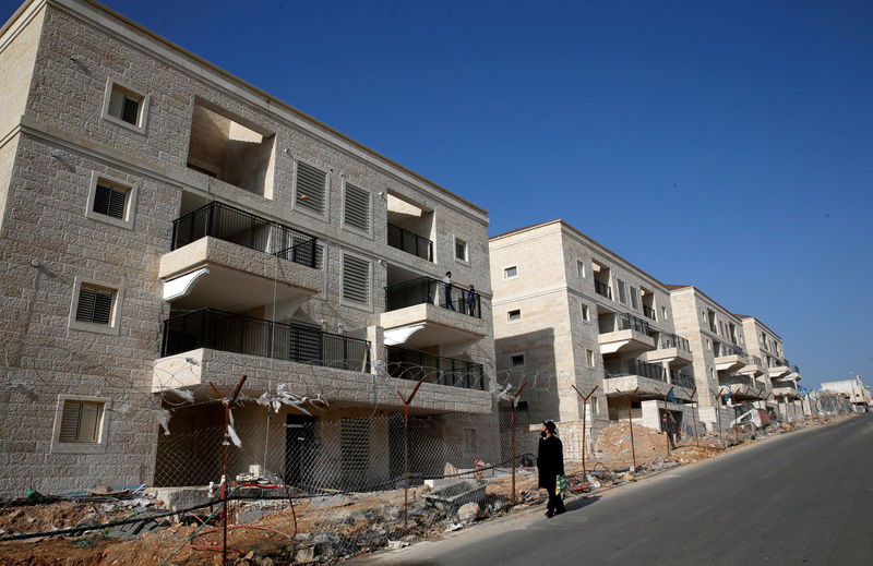 © Reuters. FILE PHOTO-  An ultra-Orthodox Jewish man walks past buildings under construction in the Israeli settlement of Beitar Ilit, in the occupied West Bank
