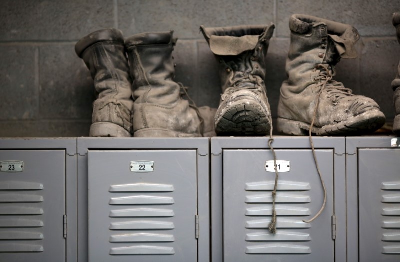 © Reuters. Coal mining boots are shown above miners' lockers before the start of an afternoon shift at a coal mine near Gilbert