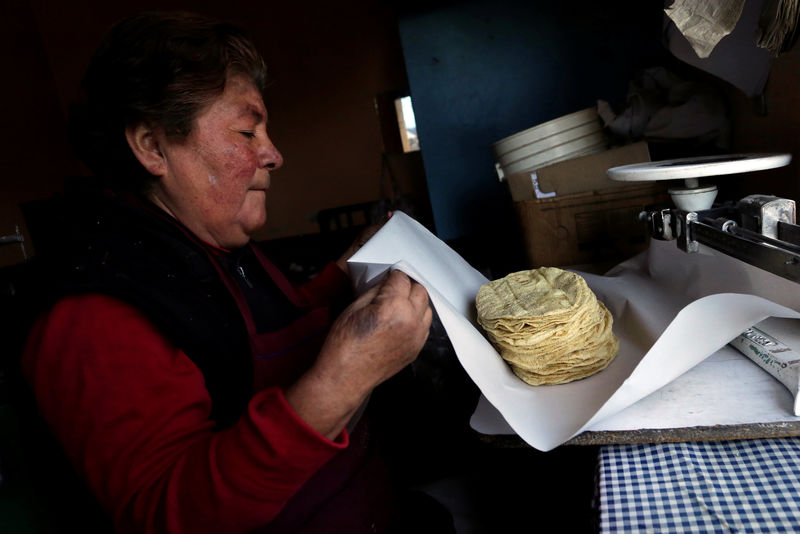 © Reuters. Woman wraps a stack of freshly made corn tortillas at a tortilla factory in Mexico City