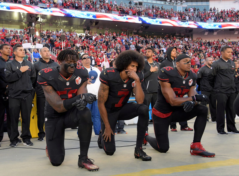 © Reuters. FILE PHOTO: San Francisco 49ers outside linebacker Harold, quarterback Kaepernick and free safety Reid kneel in protest during the playing of the national anthem before a NFL game against the Arizona Cardinals in Santa Clara