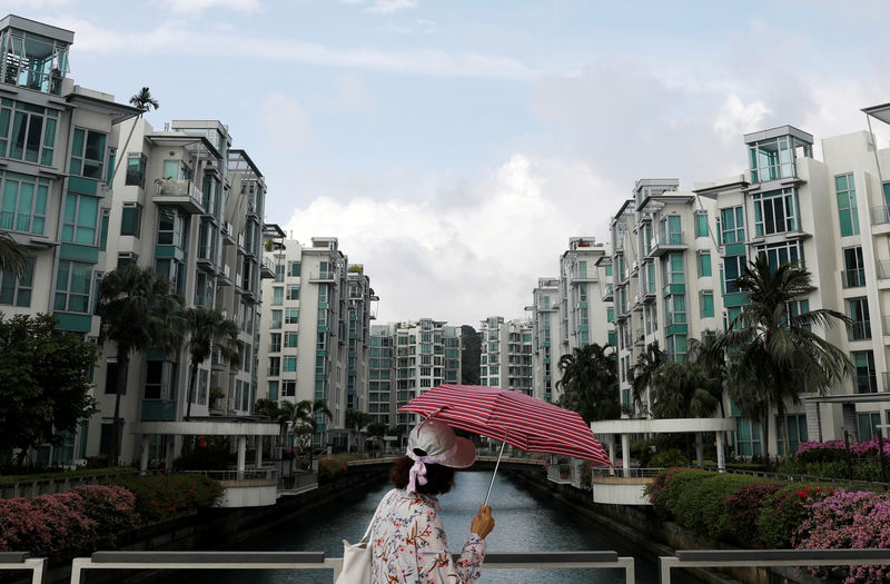 © Reuters. FILE PHOTO: A woman passes a private condominium estate in Singapore