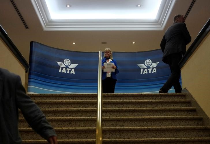 © Reuters. FILE PHOTO: A hostess stands near IATA logos during an IATA meeting in Cancun