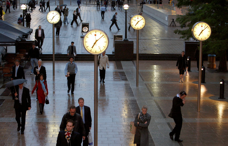 © Reuters. FILE PHOTO: Workers walk through the Canary Wharf financial district of London