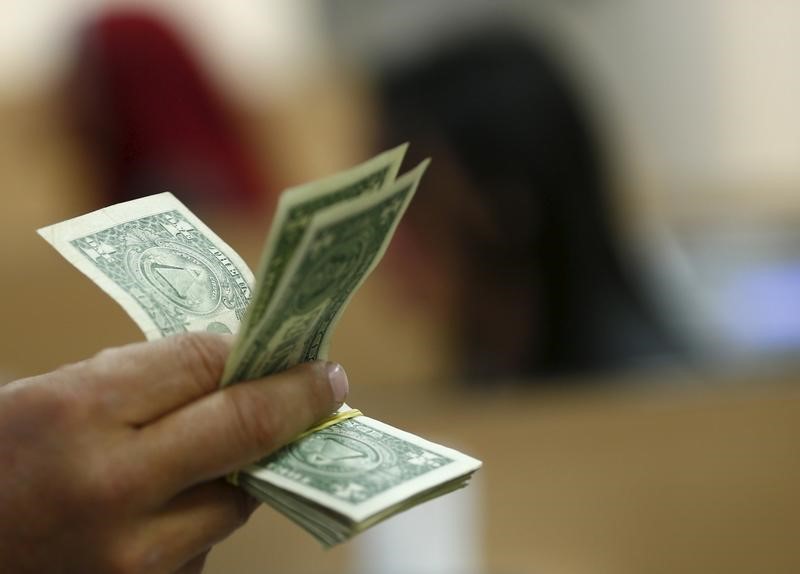 © Reuters. Pessoa segura notas de dólar em bank em Cairo, Egito