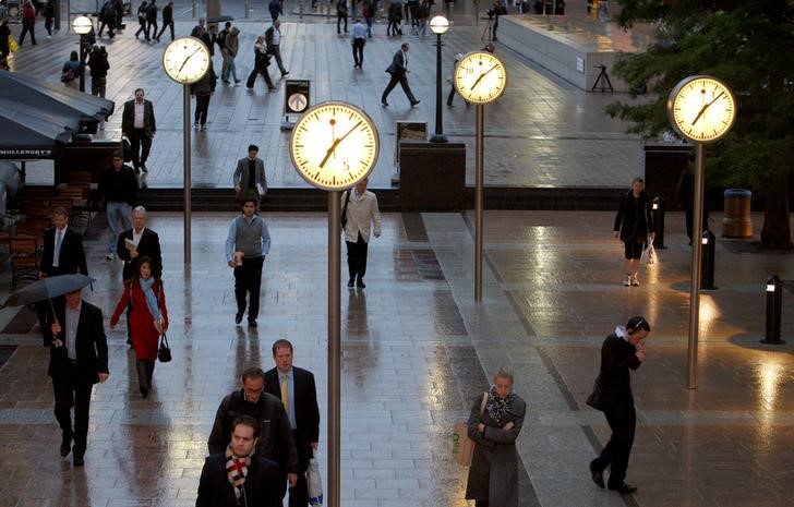 © Reuters. FILE PHOTO: Workers walk through the Canary Wharf financial district of London