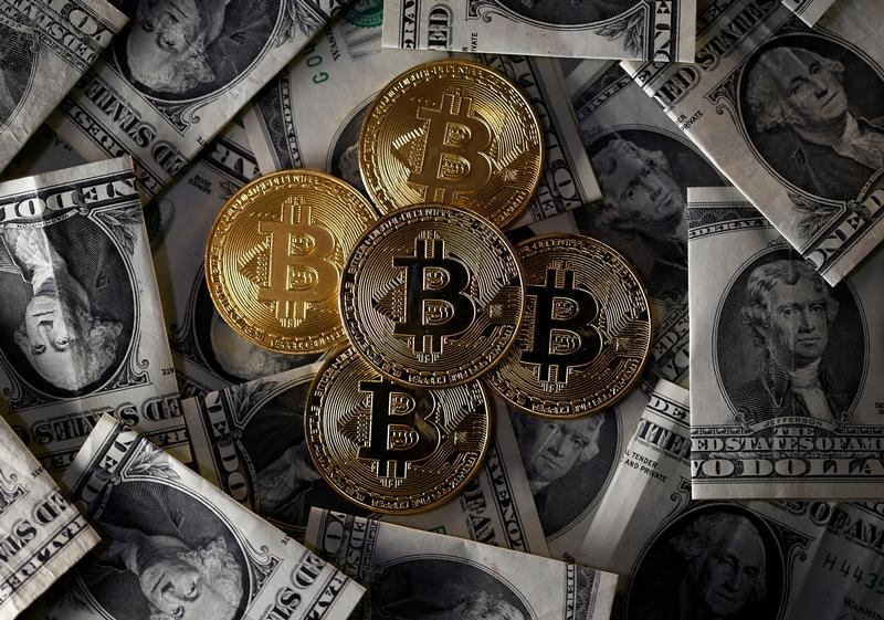 © Reuters. Ilustrações da moeda virtual bitcoin sobre notas de dólar