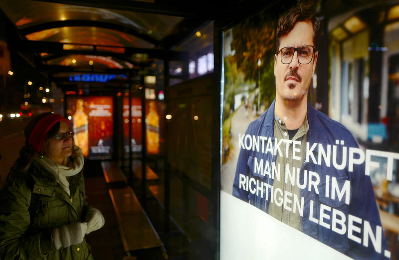 © Reuters. A woman looks at a Facebook advertisement in Berlin
