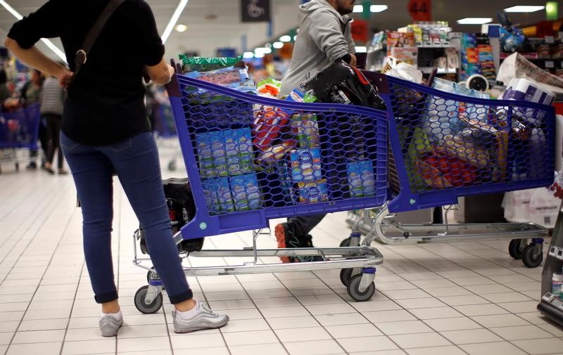 © Reuters. Customers stand next to shopping trolleys as they shop in a Carrefour hypermarket in Nice