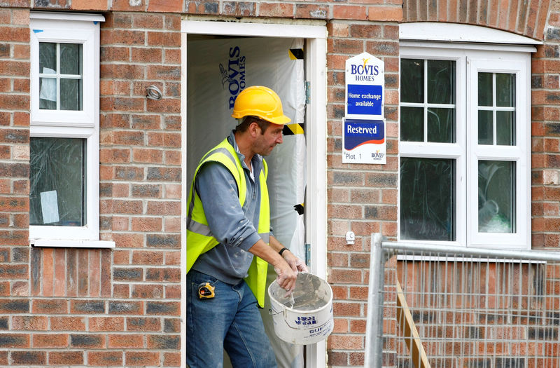 © Reuters. FILE PHOTO: A builder works at a Bovis homes housing development near Bolton