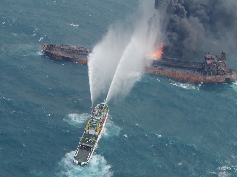 © Reuters. A rescue ship works to extinguish the fire on the stricken Iranian oil tanker Sanchi in the East China Sea