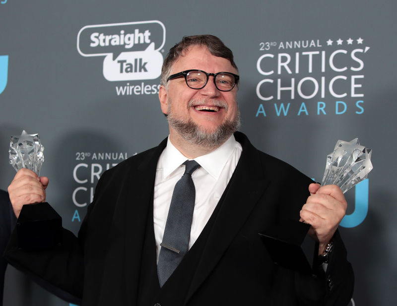 © Reuters. Guillermo del Toro posa con los premios de mejor película y mejor director en la edición número 23 de los Critics' Choice Awards