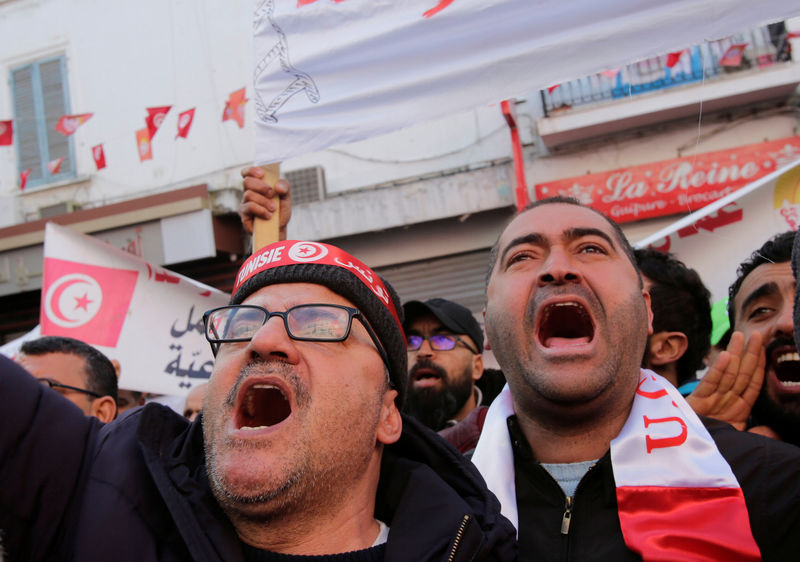 © Reuters. People shout slogans during demonstrations on the seventh anniversary of the toppling of president Zine El-Abidine Ben Ali, in Tunis